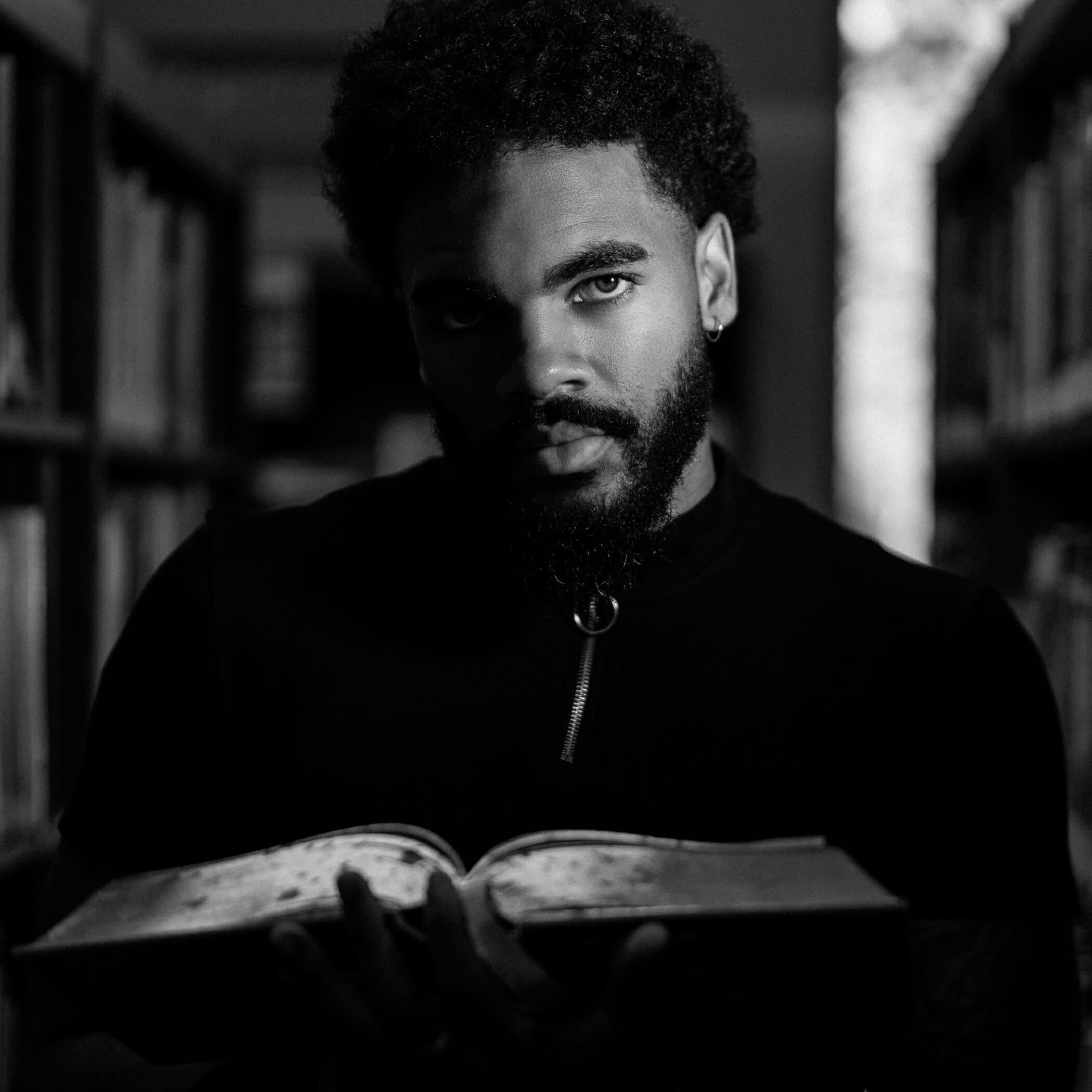 Kris holding up a book in the library, lit by one Rotolight Neo to camera-right.
