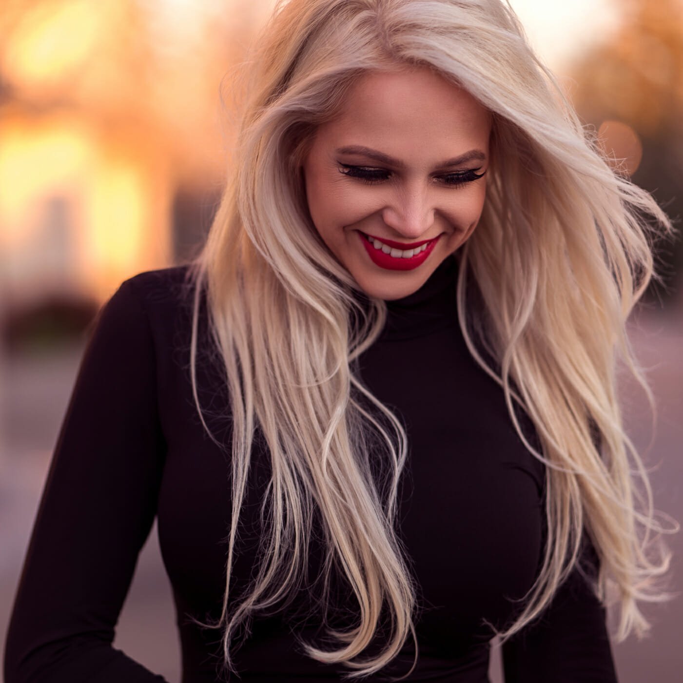 Irina with long blond hair and black top. Three quarter shot and she is looking down and excited about what is to come!